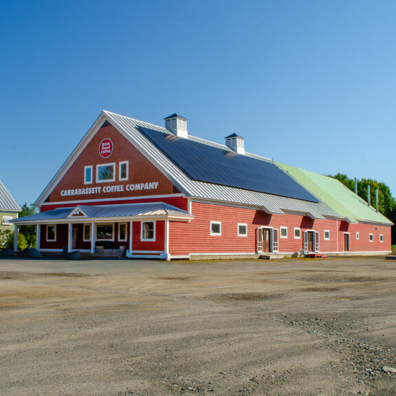 A photograph of Carrabassett Coffee Company from the side, showing the contruction and solar panels